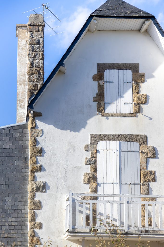 Façade de maison bretonne associant pierre apparente et enduit clair sur le littoral morbihannais
