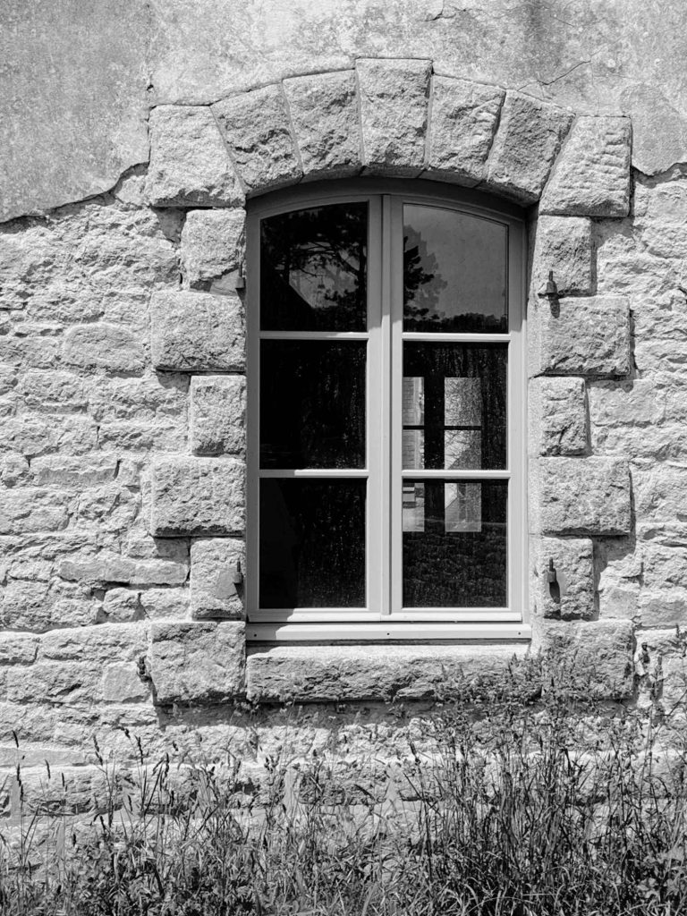 Détail d’une fenêtre en bois sur mur en pierre d'une maison ancienne à Carnac