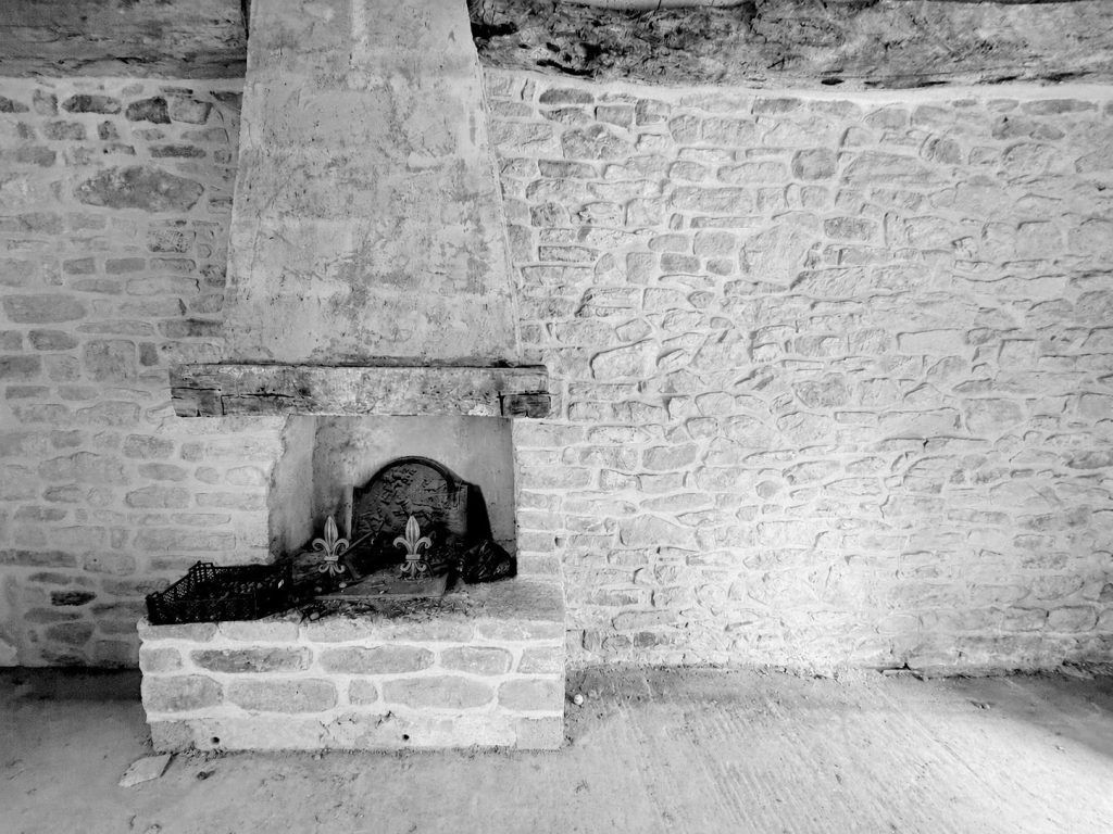 Cheminée ancienne, poutre et mur en pierre dans une longère à aménager