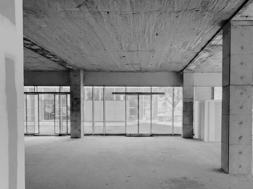 Projet de bureaux dans le Morbihan avec façade vitrée, poteaux béton et volume brut