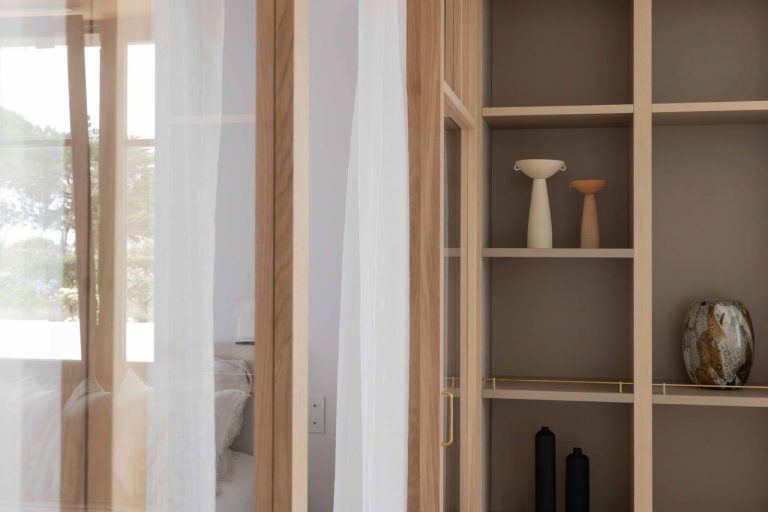 Voilage léger en lin blanc, menuiserie en chêne et bibliothèque sur mesure dans une maison rénovée à Carnac