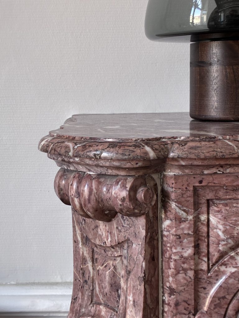 Détail d’une cheminée ancienne en marbre rose dans un intérieur de caractère à Vannes.