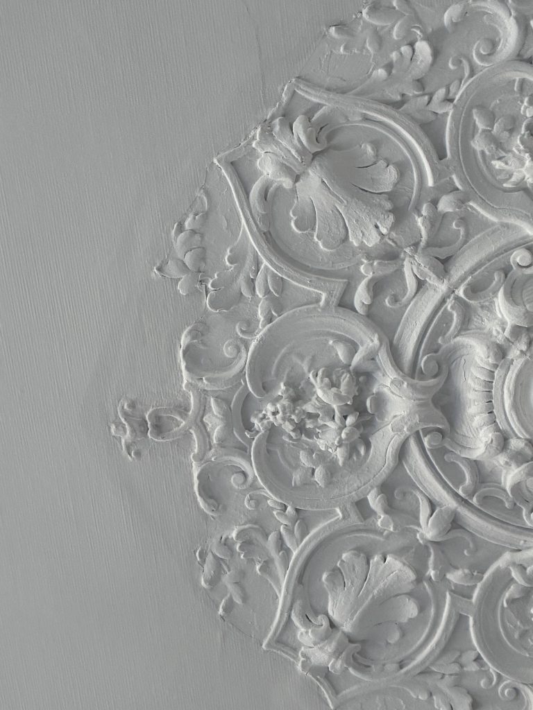 Détail d’une rosace ancienne en plâtre dans un intérieur de caractère à Vannes.